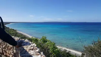 a person standing on a wall looking at the ocean at La Casita De La Cueva in Cabo Rojo
