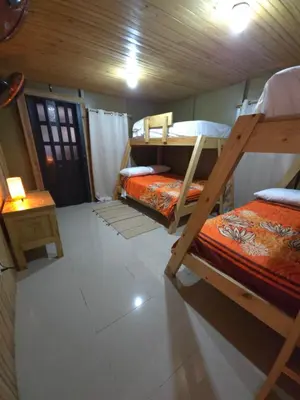 a room with two bunk beds and a table at La Casita De La Cueva in Cabo Rojo