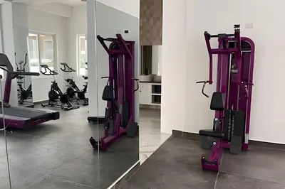 a gym with purple tread machines and a mirror at Sweet Home Bayahibe in Bayahibe