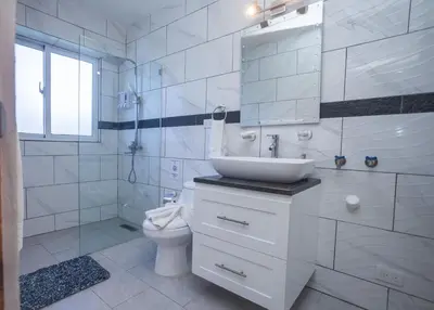 a white bathroom with a sink and a toilet at Sosua Residence by CJDR in Sosúa