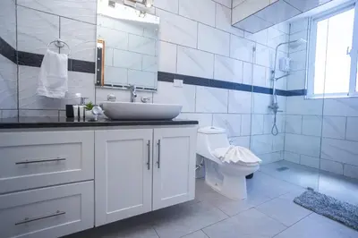 a white bathroom with a sink and a toilet at Sosua Residence by CJDR in Sosúa
