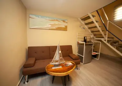 a living room with a couch and a table with a boat on it at JEYMAR STUDIO rd in Santo Domingo