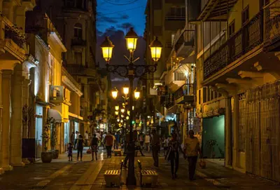 a street at night with people walking down the street at JEYMAR STUDIO rd in Santo Domingo