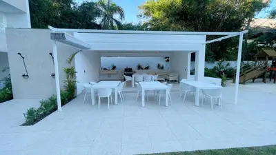a white patio with white tables and chairs at Luxury penthouse with panoramic ocean view in Punta Cana