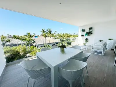 a white dining room with a white table and chairs at Luxury penthouse with panoramic ocean view in Punta Cana
