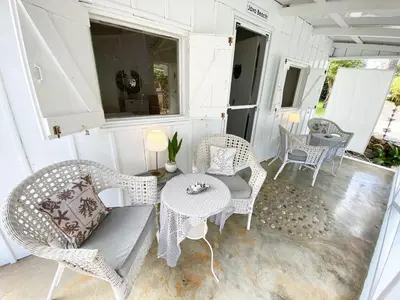 a porch with wicker chairs and a table at The Cottage at Javo beach in Las Galeras