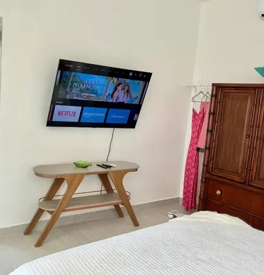 a room with a table and a tv on the wall at Vibe Residence Gorgeous Penthouse with Jacuzzi & outstanding Sea & Natural Preserve view in La Laguna