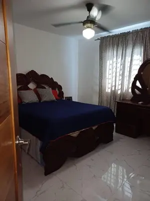 a bedroom with a bed with a blue comforter and a ceiling at Residencial Génesis III in Colorado