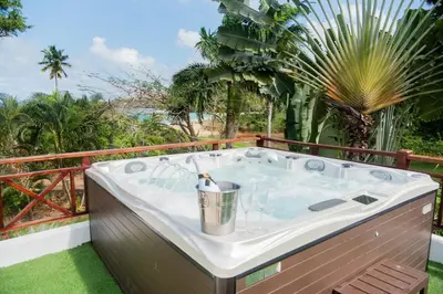 a hot tub on a balcony with a palm tree at Lives off Colorada Beach in La Colmena