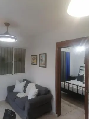 a living room with a couch and a bed at Tu espacio en zona colonial in Santo Domingo