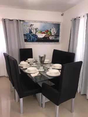 a dining room table with black chairs and a table with plates at Acogedora Casa Vacacional in Colorado