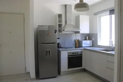 a kitchen with a stainless steel refrigerator and a sink at Depto entero, Coral Village D204, WIFI, TV, cerca de la playa in Punta Cana