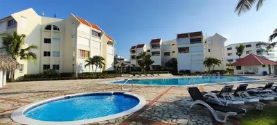 a resort with a swimming pool and chairs and buildings at Vista paraiso in La Puntica de Juan Dolio