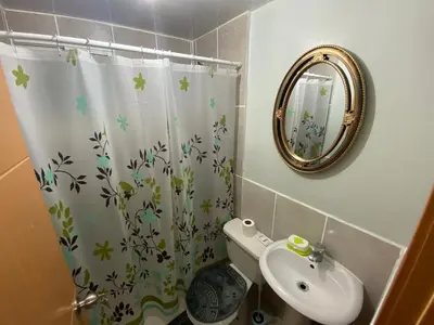 a bathroom with a shower curtain and a sink at 1st floor 3 Bedrm 2 Baths AC Condo near airport in Los Paredones