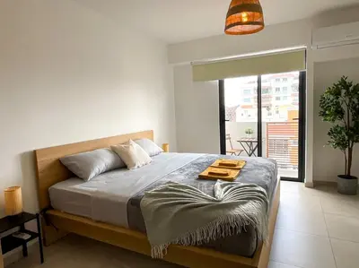 a bedroom with a bed and a large window at Comfortable Central Apartment in Santo Domingo
