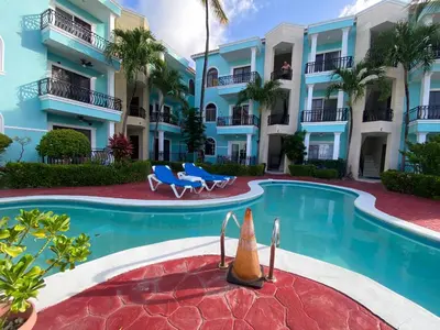 a swimming pool in front of a building at Amazing apartment pool and beach life in los corals punta cana in Punta Cana