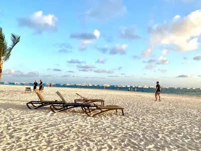 a beach with two lounge chairs and the ocean at Amazing apartment pool and beach life in los corals punta cana in Punta Cana