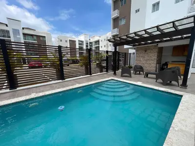 a swimming pool in front of a building at Modern Apt in Santiago w Pool, 3 Bedrooms, Air conditioner in Santiago de los Caballeros