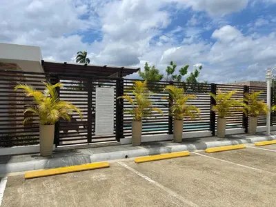 a row of palm trees in a parking lot at Modern Apt in Santiago w Pool, 3 Bedrooms, Air conditioner in Santiago de los Caballeros