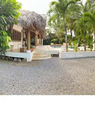 a resort with a pool and a building with palm trees at Villa de Lima in Las Terrenas