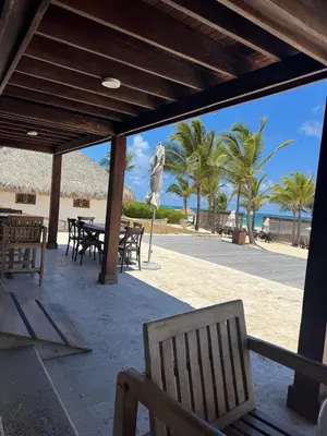 a patio with a table and chairs on the beach at Canarock Beach Club in Punta Cana