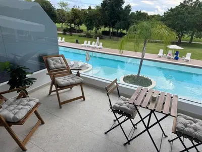 a patio with chairs and a table and a pool at Canarock Beach Club in Punta Cana