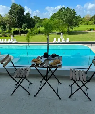 a table and chairs next to a swimming pool at Canarock Beach Club in Punta Cana