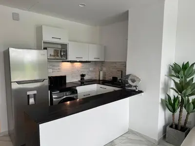 a kitchen with a black counter top and a refrigerator at Canarock Beach Club in Punta Cana