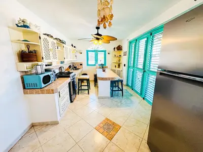 a kitchen with a refrigerator and a table with chairs at La Dolce Vita in Las Terrenas