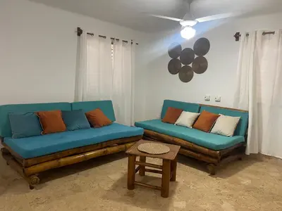 a living room with two blue couches and a table at Villa La Palmeras - 8 Pax, 5 min de La Playa in Las Galeras