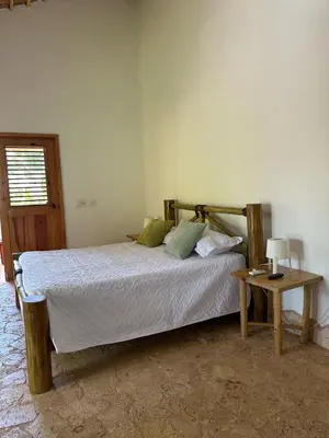 a bedroom with a bed and a table with a lamp at Villa La Palmeras - 8 Pax, 5 min de La Playa in Las Galeras
