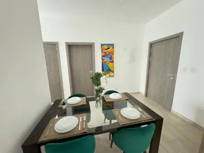 a dining room with a table and blue chairs at Casa Mulata Paseo del Mar 2 Pool & Playa in Punta Cana