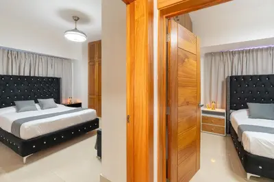 a bedroom with two beds and a closet at Modern Oasis near Monument with Rooftop BBQ , Gym, and Free Parking in Santiago de los Caballeros