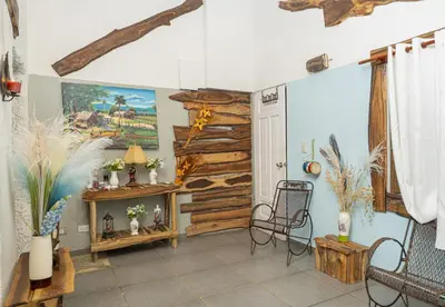 a living room with a fireplace and a wooden wall at 1Vida Bar Restaurante in Guayacanes