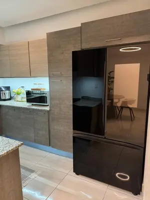 a kitchen with a black refrigerator in a room at Andrea Victoria in Santo Domingo