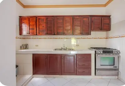 a kitchen with wooden cabinets and a stove at Rio San Juan,Spacious,Local,3 Bedroom in Río San Juan