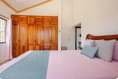 a bedroom with a large bed and wooden cabinets at Rio San Juan,Spacious,Local,3 Bedroom in Río San Juan