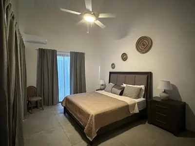 a bedroom with a bed and a ceiling fan at VILLA CORAL Tracadero Beach Resort in La Laguna