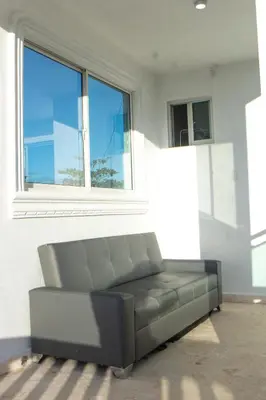 a couch sitting in a room with a window at Villa Rosa Boca Chica in Boca Chica