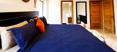 a bedroom with a blue bed with pillows at AMAR'E beach front apartment overlooking pool in Las Terrenas