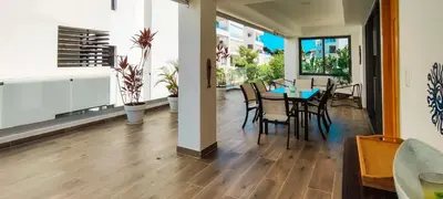 a dining room and living room with a table and chairs at AMAR'E beach front apartment overlooking pool in Las Terrenas