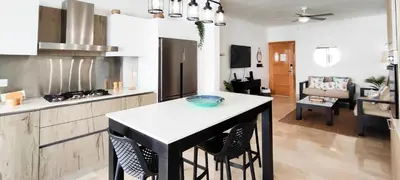 a kitchen with a island in the middle of a room at AMAR'E beach front apartment overlooking pool in Las Terrenas