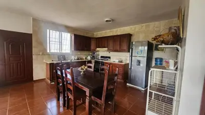 a kitchen with a table with chairs and a refrigerator at Essential Life La Cuaba Casa de Campo Amenities in Pedro Brand