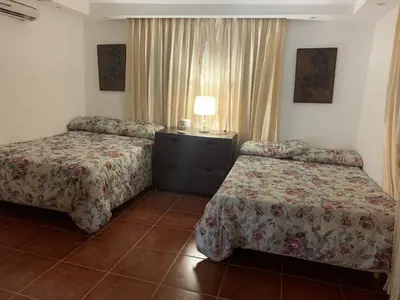 a hotel room with two beds and a table with a lamp at Essential Life La Cuaba Casa de Campo Amenities in Pedro Brand