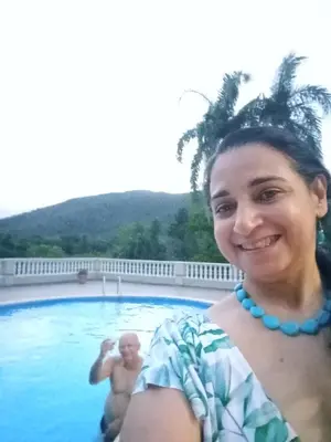 a woman standing in a pool with a man in the water at Essential Life La Cuaba Casa de Campo Amenities in Pedro Brand