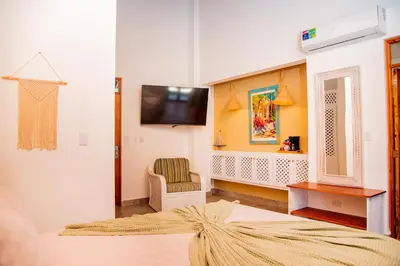 a bedroom with a bed and a tv on a wall at Central Hotel Boutique in Las Galeras