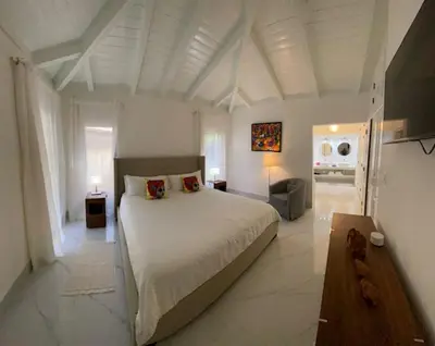 a large white bedroom with a large bed in it at Villa Allegria Los Lagos 57 in La Romana