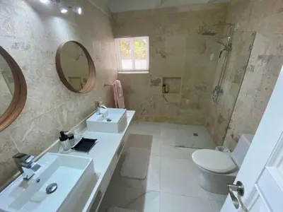 a bathroom with a sink and a toilet and a mirror at Villa Allegria Los Lagos 57 in La Romana