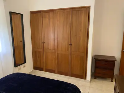 a bedroom with a large wooden cabinet and a dresser at FreshBreeze - Apartment Near US Embassy in Santo Domingo
