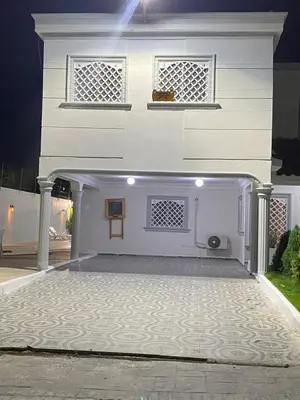 a white house with a front porch at night at Villa Gordon in Santa Cruz de Barahona